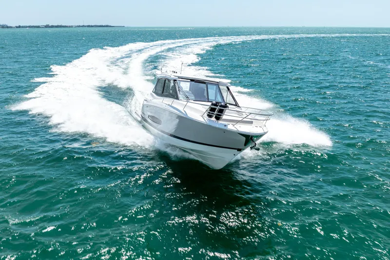 Slide: The Image of 2022 Regal 36 Grande Coupe cruising on open water, creating a dynamic wake. - 10