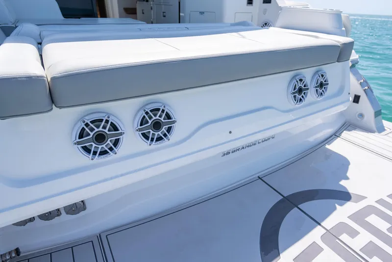 Slide: The Image of 2022 Regal 36 Grande Coupe boat with speakers on deck, ocean backdrop. - 62