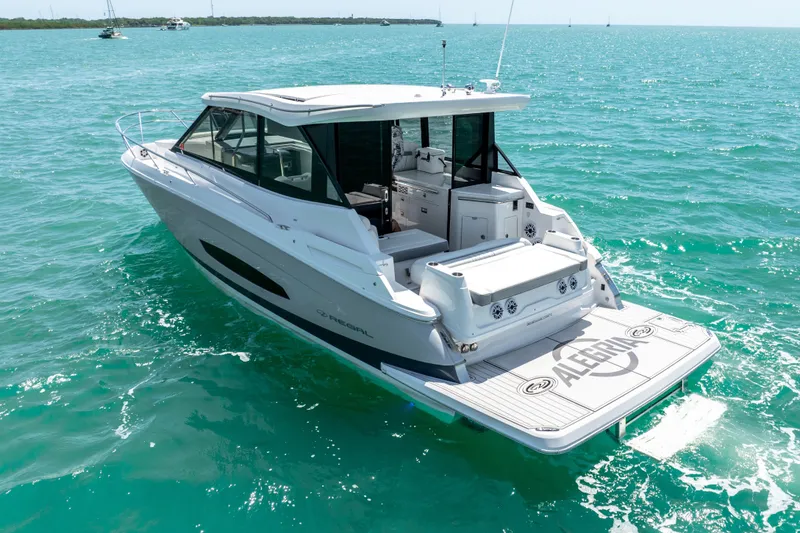 Slide: The Image of 2022 Regal 36 Grande Coupe yacht cruising on turquoise waters. - 9