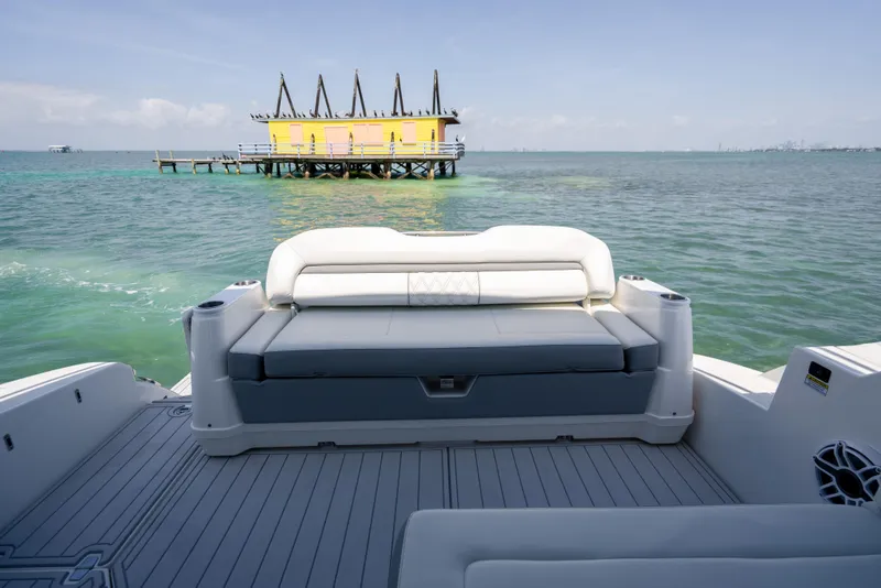 Slide: The Image of 2022 Regal 36 Grande Coupe boat with ocean view and distant yellow house on stilts. - 65