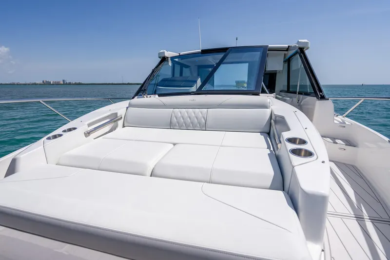 Slide: The Image of 2022 Regal 36 Grande Coupe yacht with luxurious white seating on open water. - 16