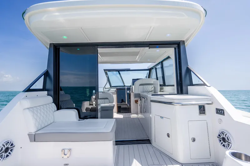 Slide: The Image of 2022 Regal 36 Grande Coupe yacht interior with luxurious seating and ocean view. - 23