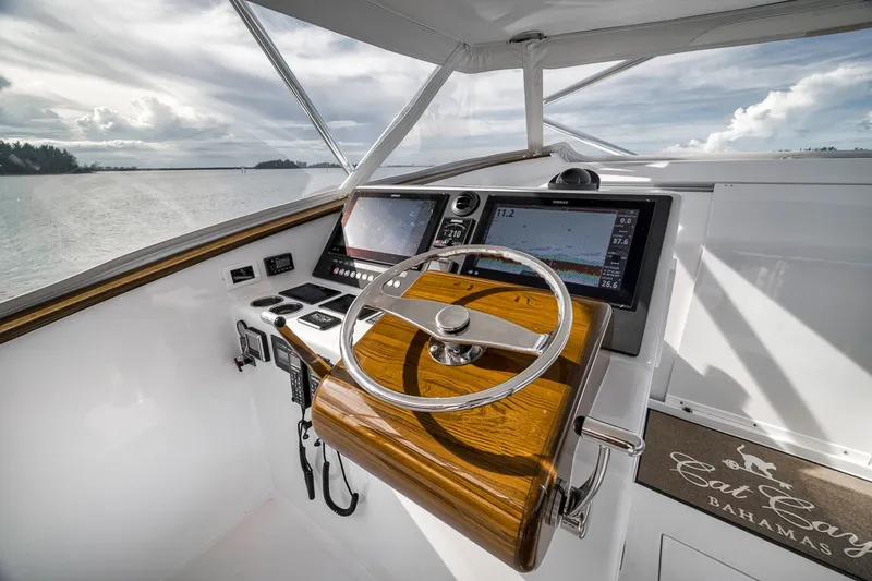 Slide: The Image of Helm of 2025 Release Boatworks 46 Express with modern navigation displays and wooden steering wheel. - 59