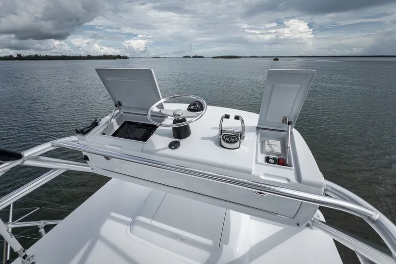 Slide: The Image of 2025 Release Boatworks 46 Express helm with open compartments, steering wheel, and throttle controls. - 30