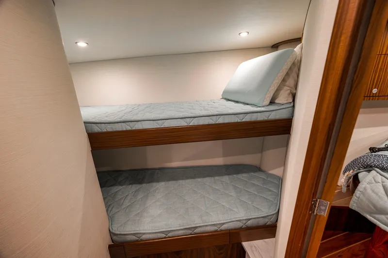 Slide: The Image of 2025 Release Boatworks 46 Express cabin with cozy bunk beds and soft lighting. - 71