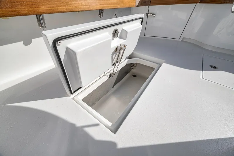 Slide: The Image of Open storage compartment on 2025 Release Boatworks 46 Express deck. - 53