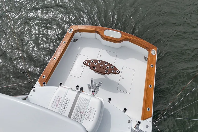 Slide: The Image of 2025 Release Boatworks 46 Express cockpit with wooden trim, viewed from above on water. - 35