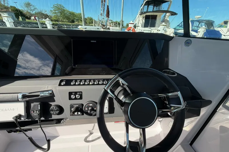 Slide: The Image of 2025 Axopar 29 XC Cross Cabin helm with modern controls and navigation system. - 13