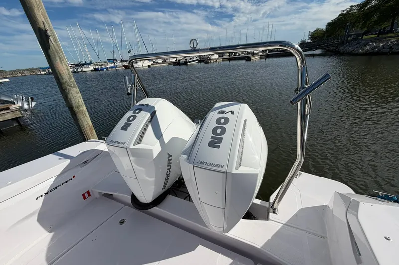 Slide: The Image of 2025 Axopar 29 XC Cross Cabin with twin Mercury 200 engines at a marina. - 6