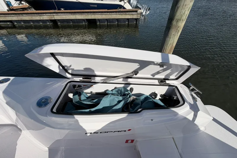 Slide: The Image of Open storage compartment on 2025 Axopar 29 XC Cross Cabin boat at dock. - 7