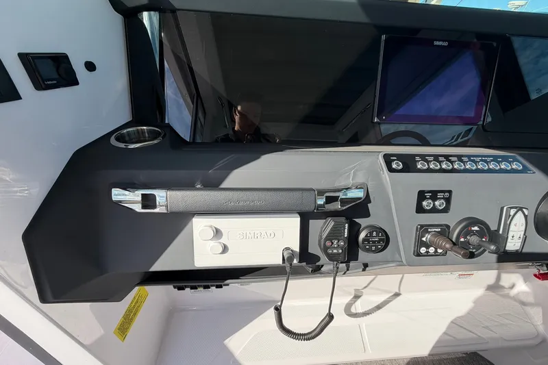 Slide: The Image of 2025 Axopar 29 XC Cross Cabin dashboard with navigation controls and Simrad display. - 14