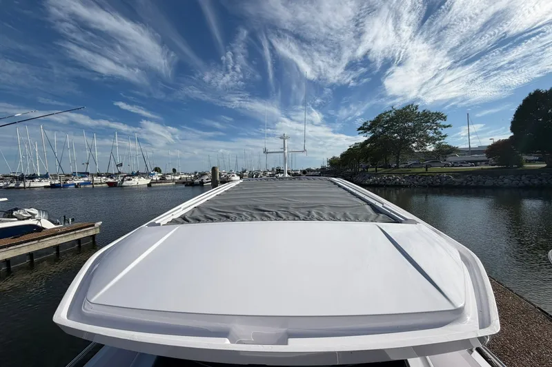 Slide: The Image of 2025 Axopar 29 XC Cross Cabin docked at a marina under a vibrant sky. - 31