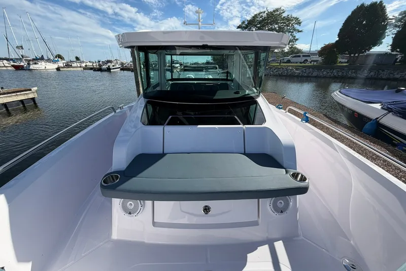 Slide: The Image of 2025 Axopar 29 XC Cross Cabin boat docked at marina, featuring sleek design and seating area. - 9