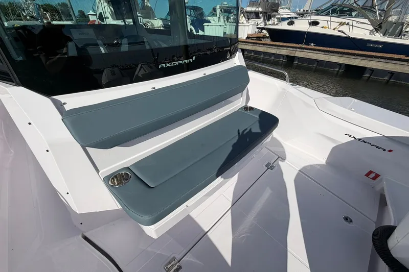 Slide: The Image of 2025 Axopar 29 XC Cross Cabin boat with cushioned seating and cup holders. - 4