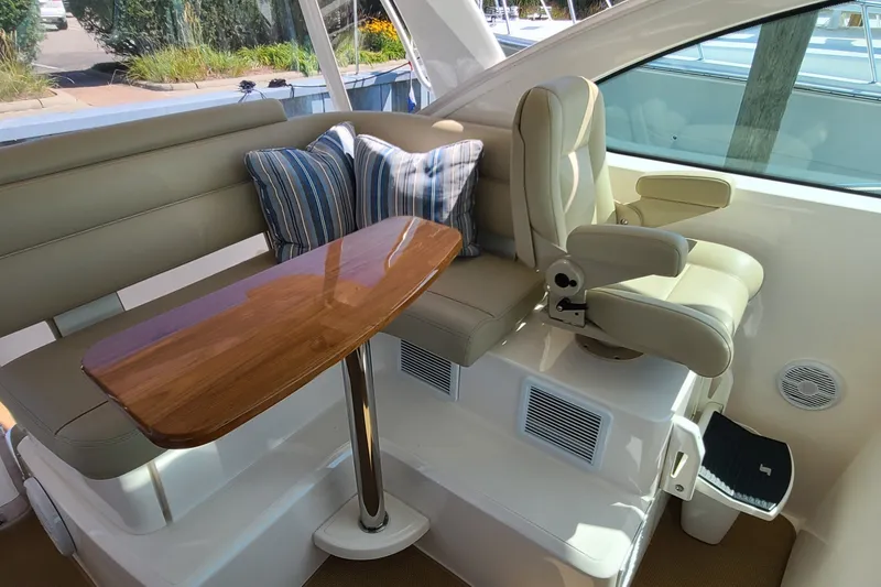 Slide: The Image of 2016 Tiara Yachts 3900 Coronet interior with seating and wooden table. - 8