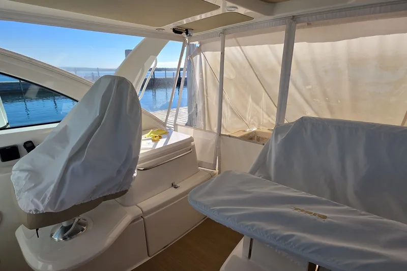 Slide: The Image of Interior of 2016 Tiara Yachts 3900 Coronet with covered seating and marina view. - 14