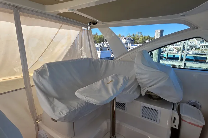 Slide: The Image of 2016 Tiara Yachts 3900 Coronet interior with covered seating and marina view. - 15