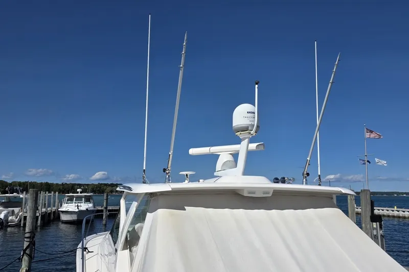 Slide: The Image of 2016 Tiara Yachts 3900 Coronet docked, featuring antennas and radar equipment under a clear blue sky. - 3