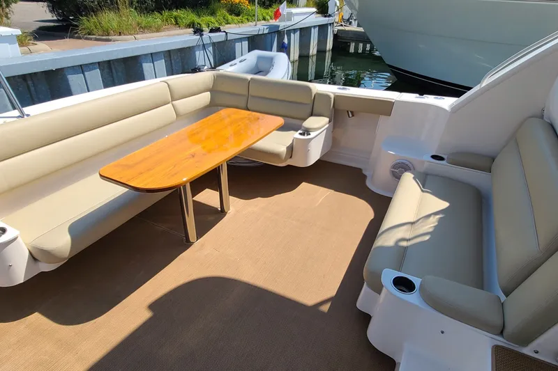 Slide: The Image of 2016 Tiara Yachts 3900 Coronet interior with beige seating and wooden table. - 11