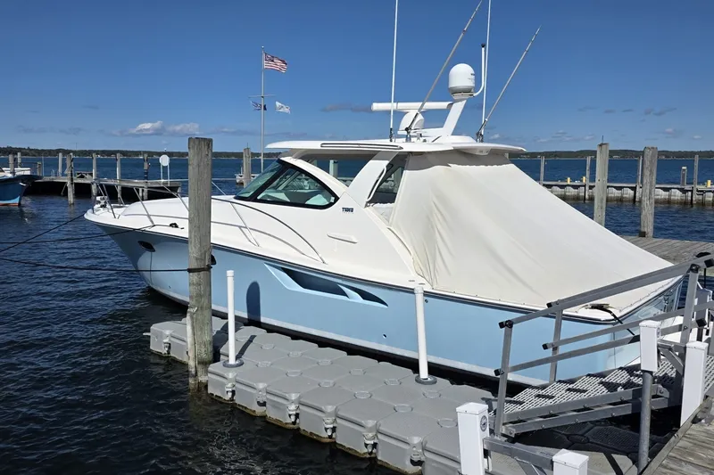 Slide: The Image of 2016 Tiara Yachts 3900 Coronet docked at marina under clear blue sky. - 2