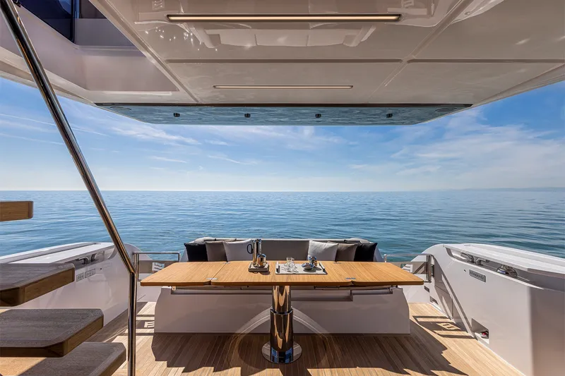 Slide: The Image of Luxurious 2025 Ferretti Yachts 580 deck with ocean view and elegant dining setup. - 14