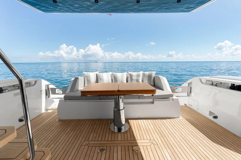 Slide: The Image of Luxurious 2025 Ferretti Yachts 580 deck with ocean view, featuring elegant seating and table. - 22