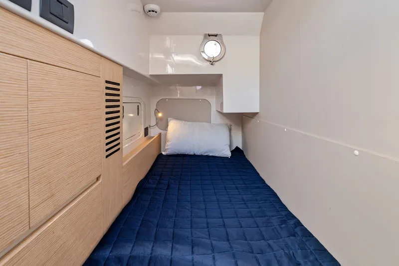 Slide: The Image of Cozy cabin interior of 2025 Ferretti Yachts 580 with blue bedding and wooden accents. - 68