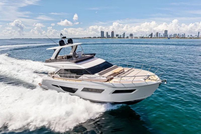 Slide: The Image of 2025 Ferretti Yachts 580 cruising on open water with city skyline backdrop. - 12