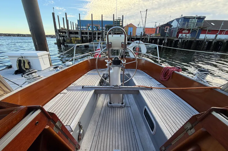 Slide: The Image of Cockpit of 1987 Vindo 45 sailboat docked at a marina, featuring wooden details. - 17