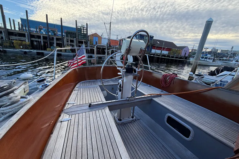 Slide: The Image of Sailboat cockpit view of 1987 Vindo 45, docked with American flag, under cloudy sky. - 19