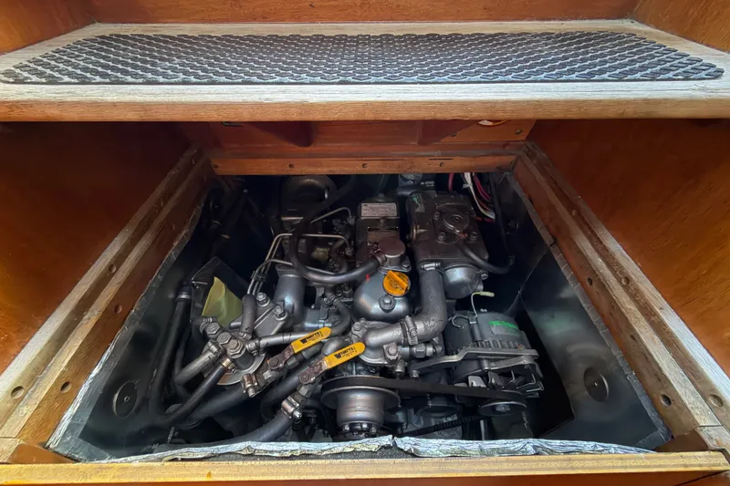 Slide: The Image of Engine compartment of a 1987 Vindo 45 sailboat, showcasing mechanical components and wiring. - 51