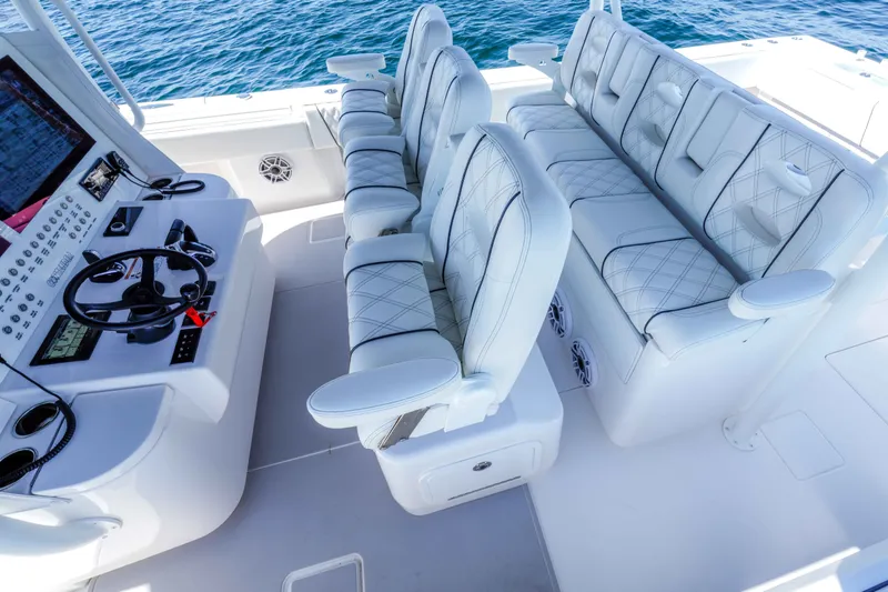 Slide: The Image of Luxurious seating and helm of 2024 Contender 44 CB boat, featuring modern controls and ocean view. - 24