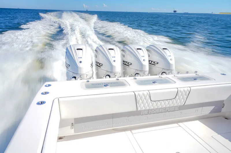 Slide: The Image of 2024 Contender 44 CB boat with four powerful outboard engines cruising on open water. - 16