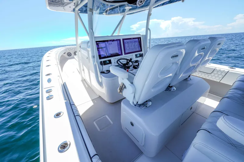 Slide: The Image of 2024 Contender 44 CB boat interior with advanced navigation system and luxurious seating on open water. - 11