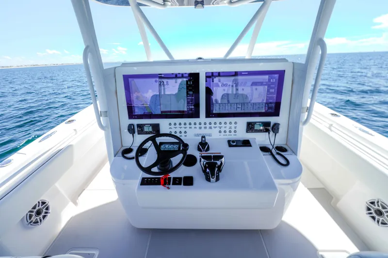 Slide: The Image of 2024 Contender 44 CB boat cockpit with advanced navigation displays on open water. - 20