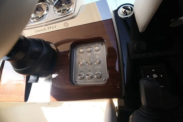 Slide: The Image of Close-up of a Chris-Craft Launch 35 GT Sterdrive dashboard with sleek wood and metal elements. - 34
