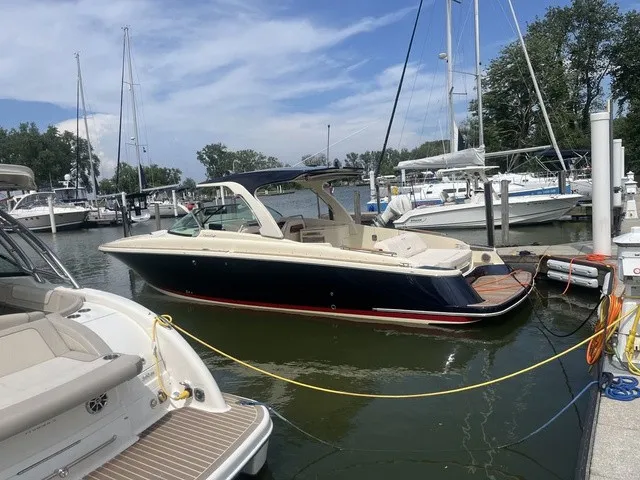 Slide: The Image of A sleek 2026 Chris-Craft Launch 35 GT Sterndrive boat docked in a marina. It features a stylish design with an open deck and luxurious seating. - 4