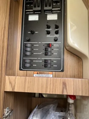 Slide: The Image of An electrical control panel in a boat with various switches and warning labels. - 16