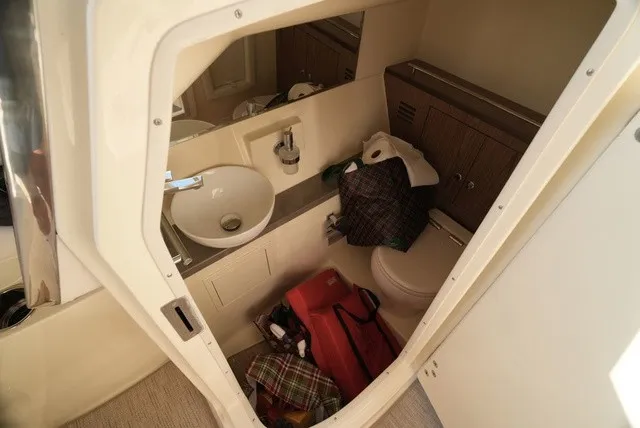 Slide: The Image of Interior of a boat cabin with a sink, toilet, and storage space. - 45