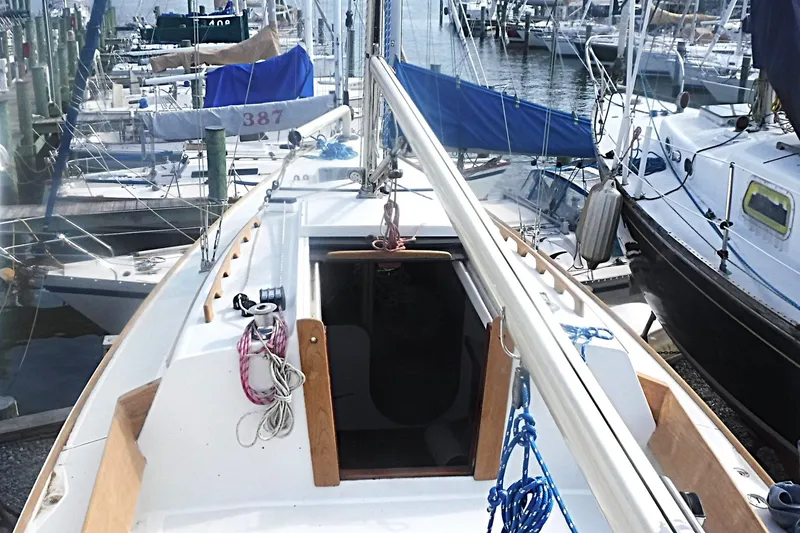 Slide: The Image of 1997 Alerion Express 28 sailboat docked at a marina, surrounded by other boats. - 17