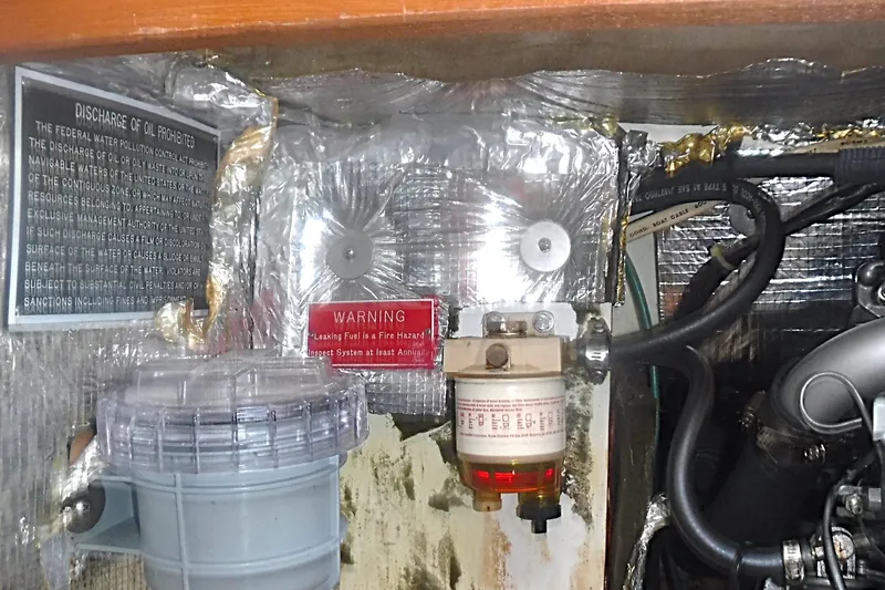 Slide: The Image of Engine compartment of a 1997 Alerion Express 28 with fuel filter and warning labels. - 33