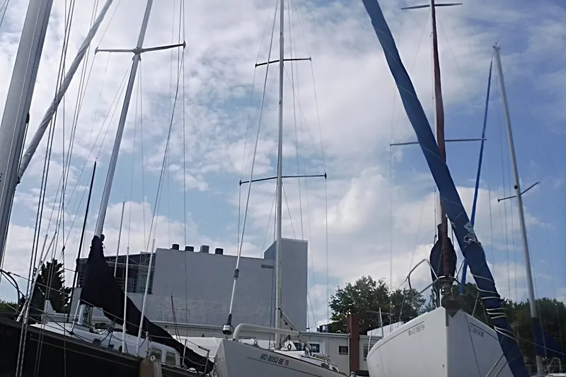 Slide: The Image of Sailboats docked under a cloudy sky, featuring a 1997 Alerion Express 28. - 5