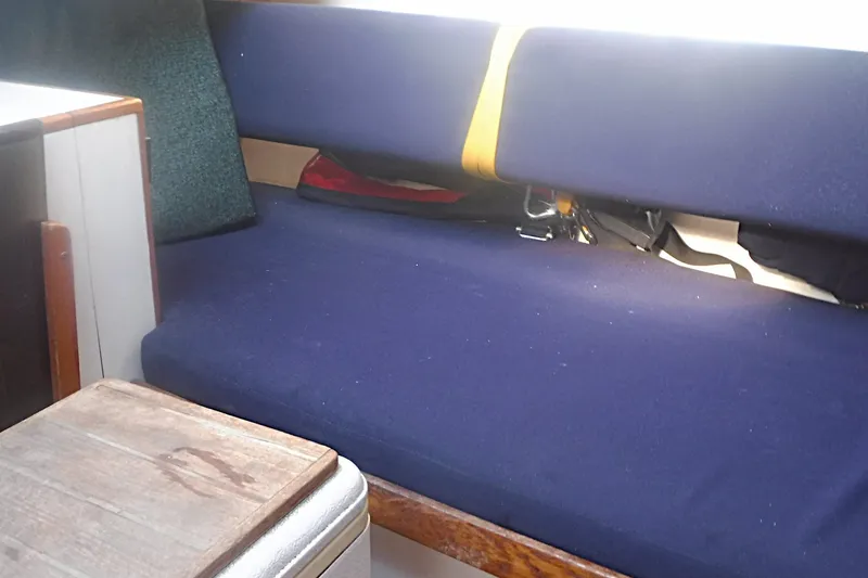 Slide: The Image of Interior of 1997 Alerion Express 28 sailboat with blue seating and wooden table. - 43