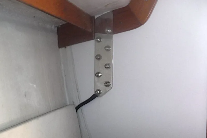 Slide: The Image of Interior view of a 1997 Alerion Express 28 sailboat, featuring a metal bracket and wooden trim. - 49