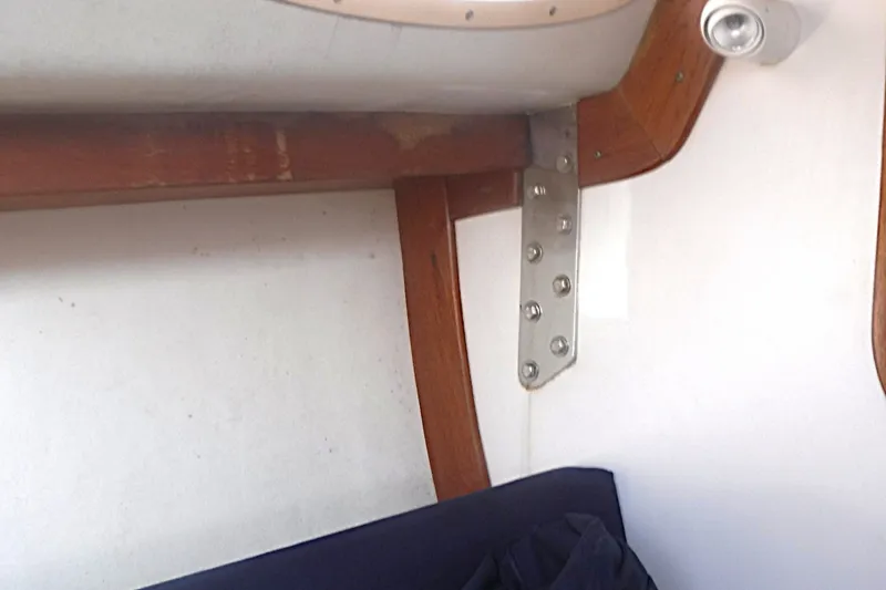 Slide: The Image of Interior detail of a 1997 Alerion Express 28 sailboat, featuring wooden trim and metal bracket. - 28