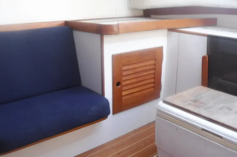 Slide: The Image of Interior of 1997 Alerion Express 28 sailboat with blue seating and wooden accents. - 38