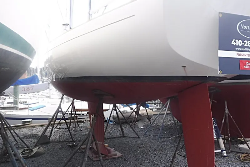Slide: The Image of 1997 Alerion Express 28 sailboat on stands in a marina, hull and keel visible. - 6