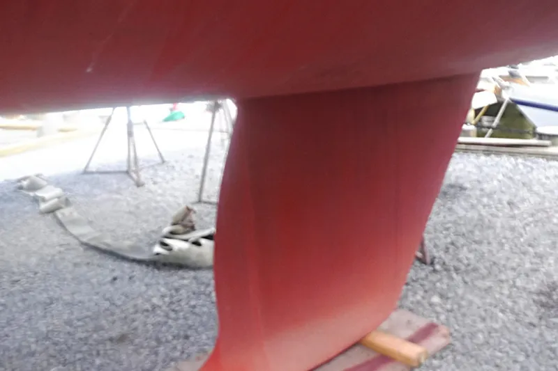 Slide: The Image of Red keel of a 1997 Alerion Express 28 sailboat on gravel. - 10