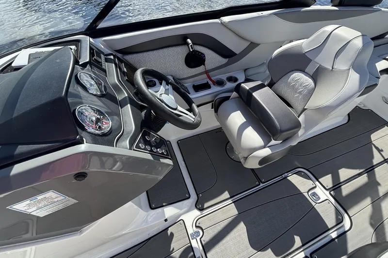 Slide: The Image of 2024 Hurricane SunDeck 2600 OB boat interior with steering wheel and captain's chair. - 9