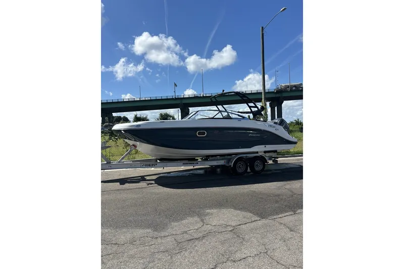 Slide: The Image of 2024 Hurricane SunDeck 2600 OB boat on trailer under blue sky. - 14